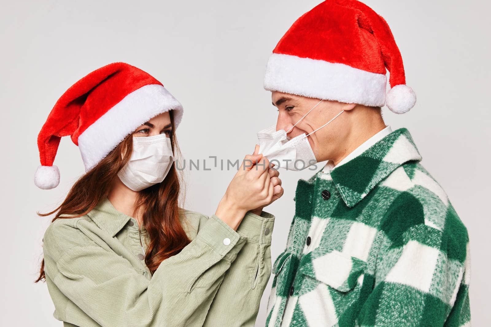 woman puts on a man a medical mask protection new year holiday together by SHOTPRIME