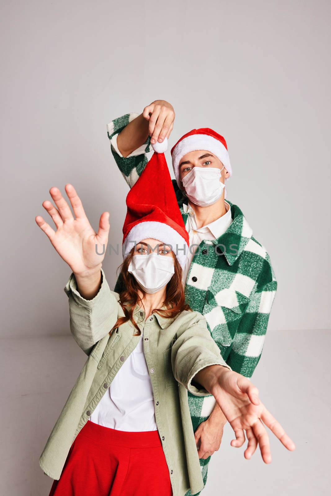 Cute young couple winter christmas medical masks celebrate new year together. High quality photo