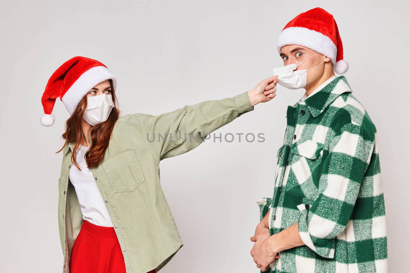 Man and woman in New Year's hats medical masks quarantine holiday New Year by SHOTPRIME