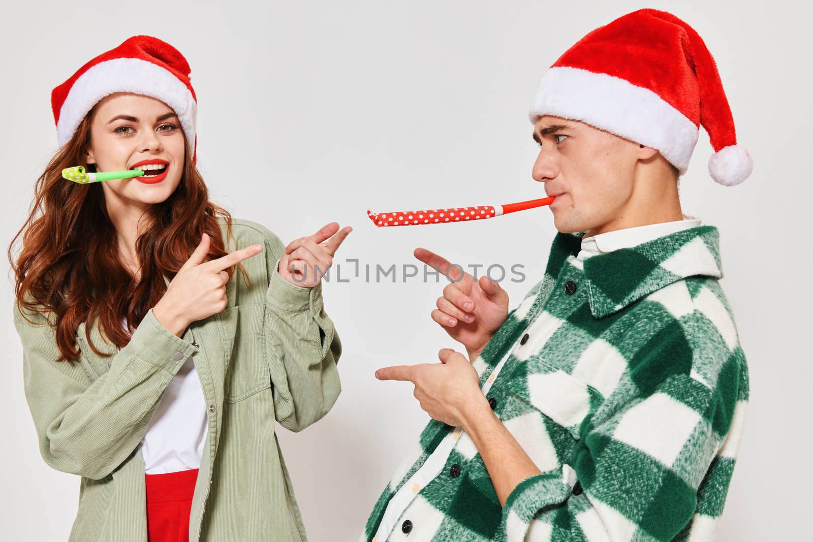 Cheerful young couple New Years holiday caps fun fashion by SHOTPRIME