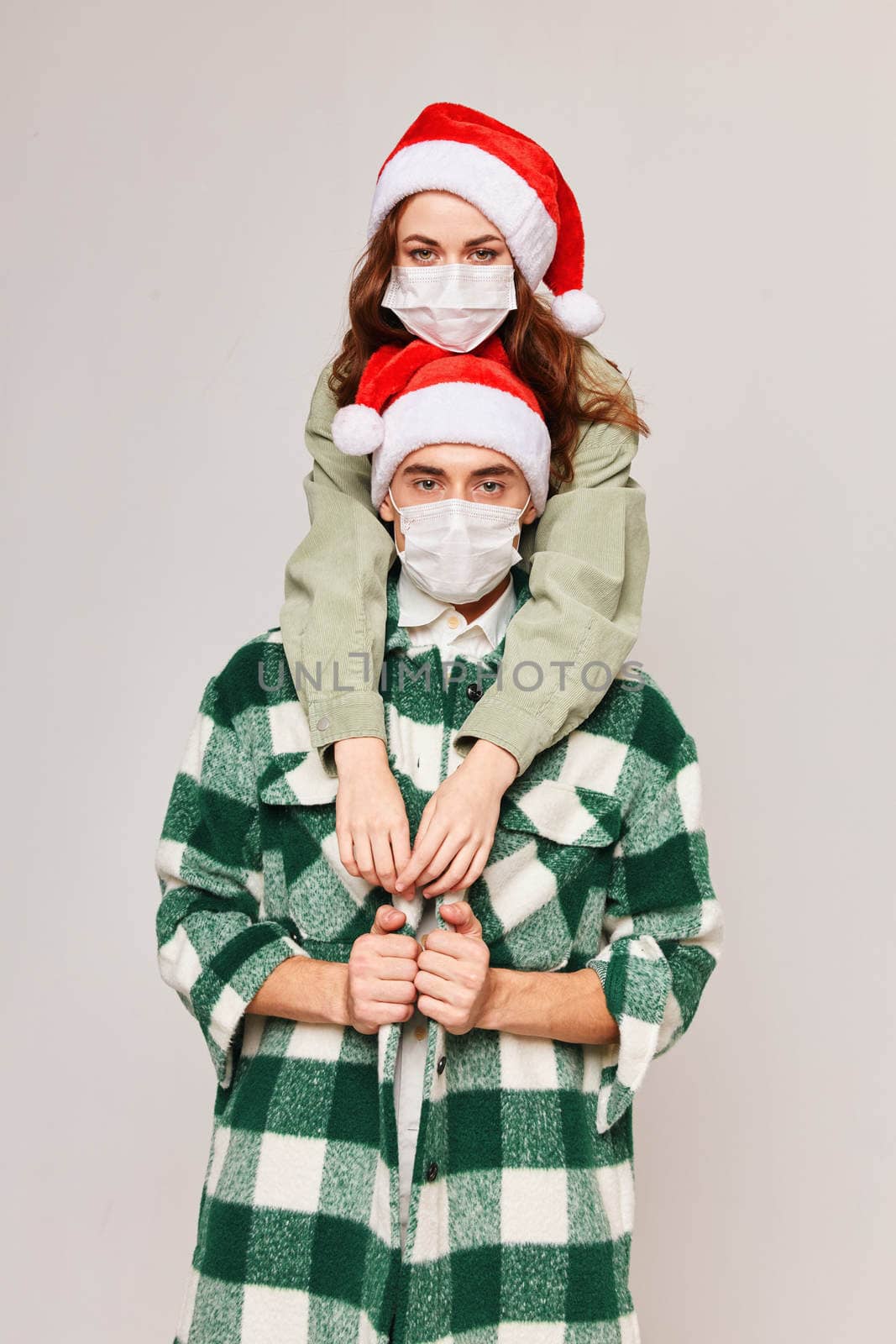 Man and woman hugs Christmas holiday fun medical masks. High quality photo