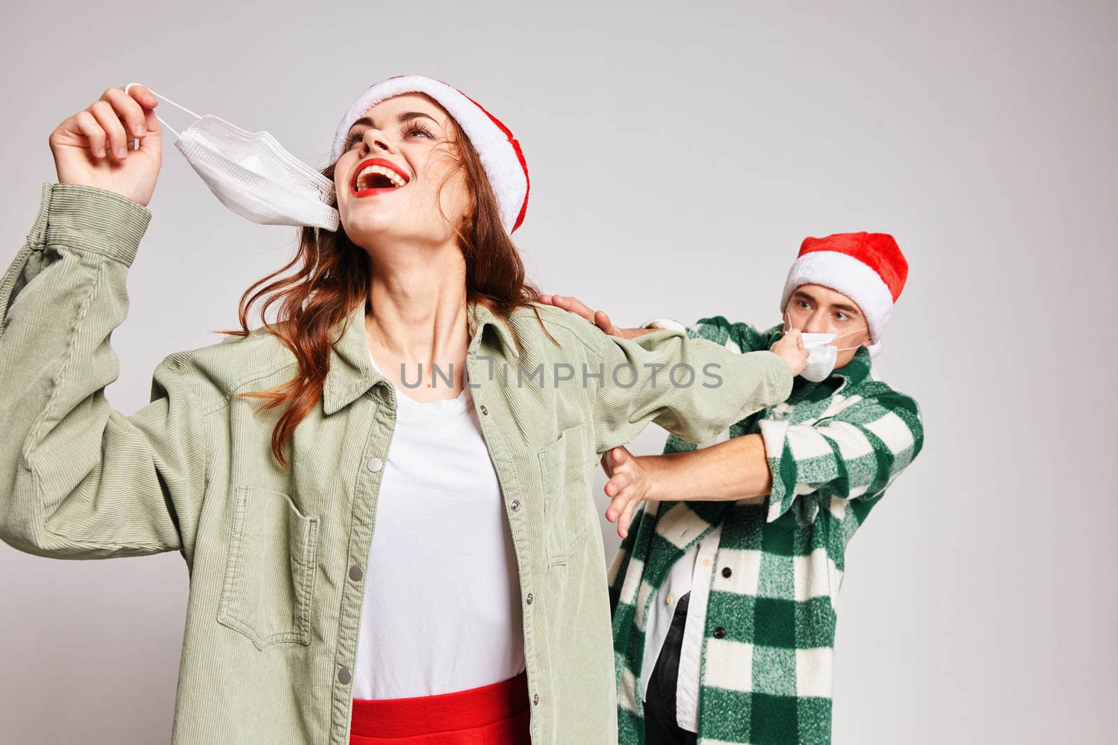 young couple medical masks christmas hats winter new year fun by SHOTPRIME