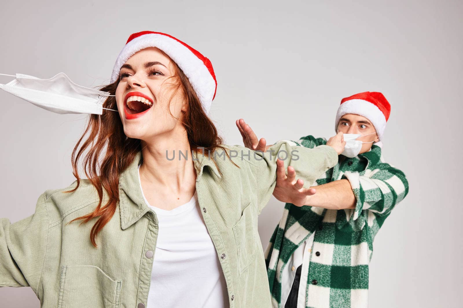 Cheerful woman and man medical masks Christmas holidays fun emotions by SHOTPRIME