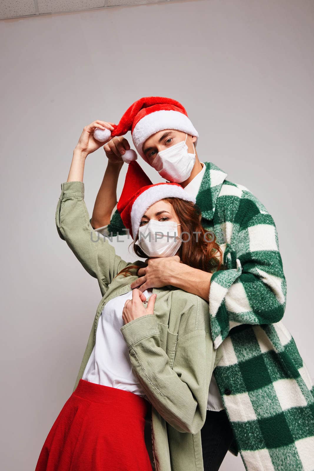 Man smothers woman Christmas hats Merry Christmas medical holiday masks by SHOTPRIME