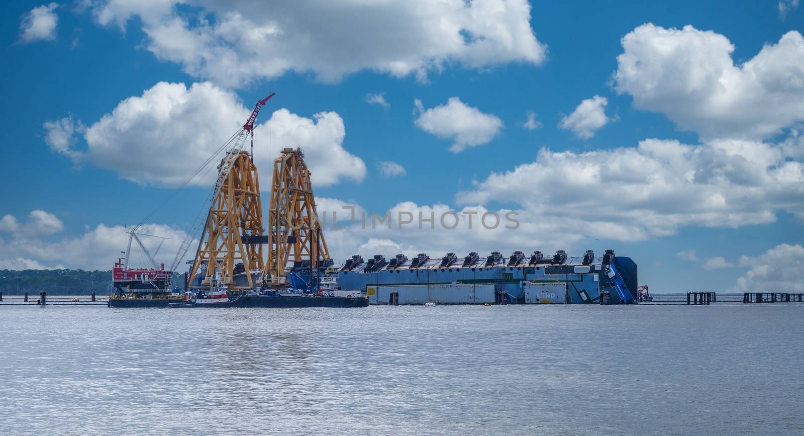 BRUNSWICK, GEORGIA - November 1, 2020: A year after a South Korean ship carrying 4,200 cars overturned, a giant floating crane is erected over it to begin cutting it up and hauling it away.