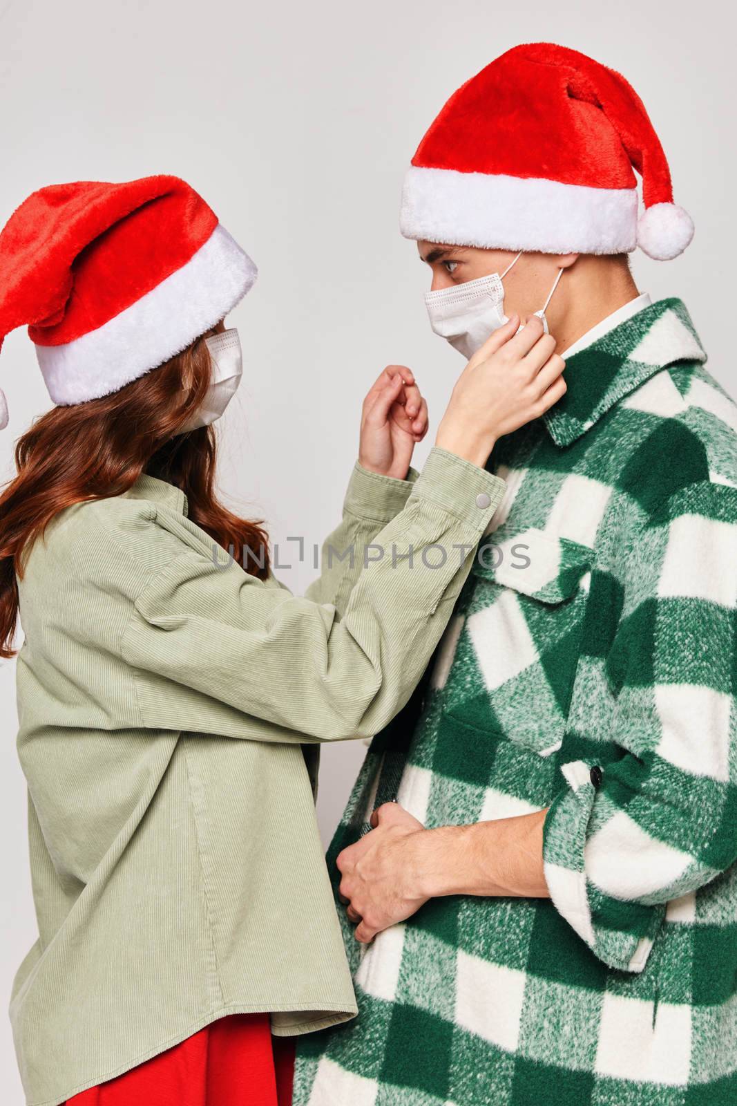 Woman puts on a medical mask to a man protection New Years holiday fun. High quality photo