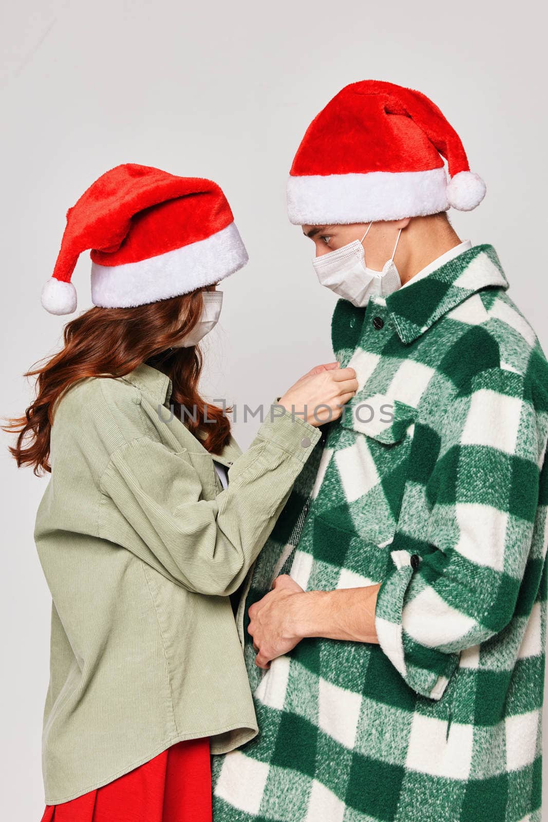 Woman buttons shirt man Christmas hats caring winter Christmas by SHOTPRIME