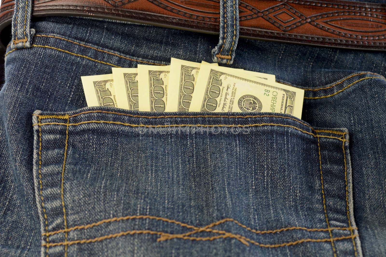 A back pocket of jeans with some American cash money emerging to show whats inside.