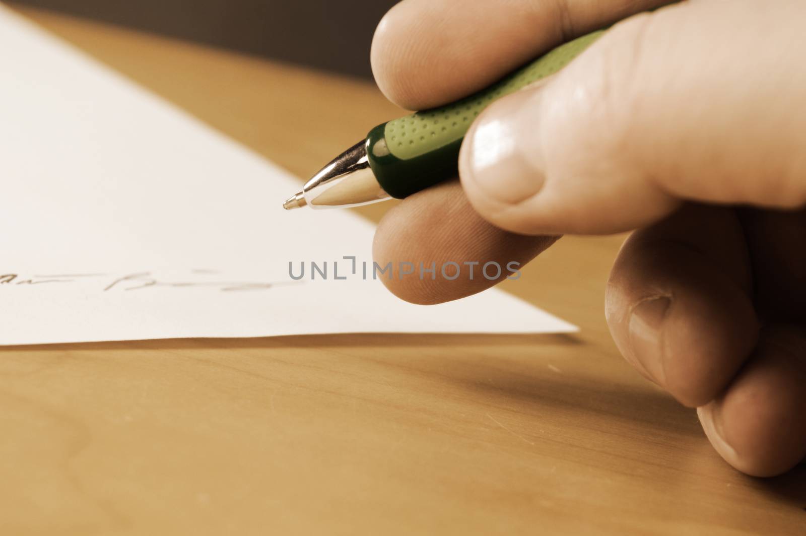 A vintage filter over an image of an important document is being signed by the appropriate person with a closeup of their hand and focus on the tip of the ball point pen.