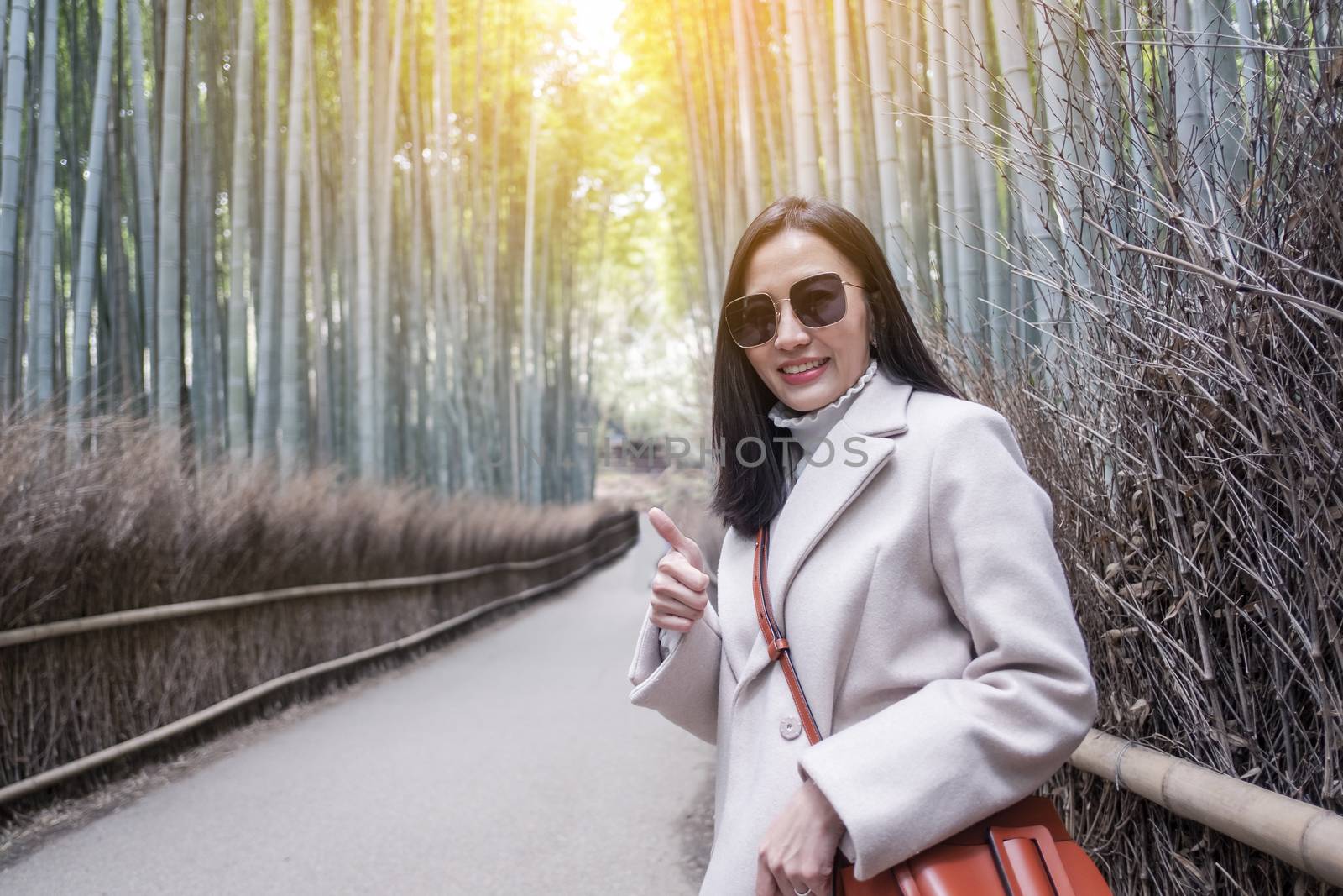  Asian woman traveling at Bamboo Forest in Kyoto, Japan.  by Surasak