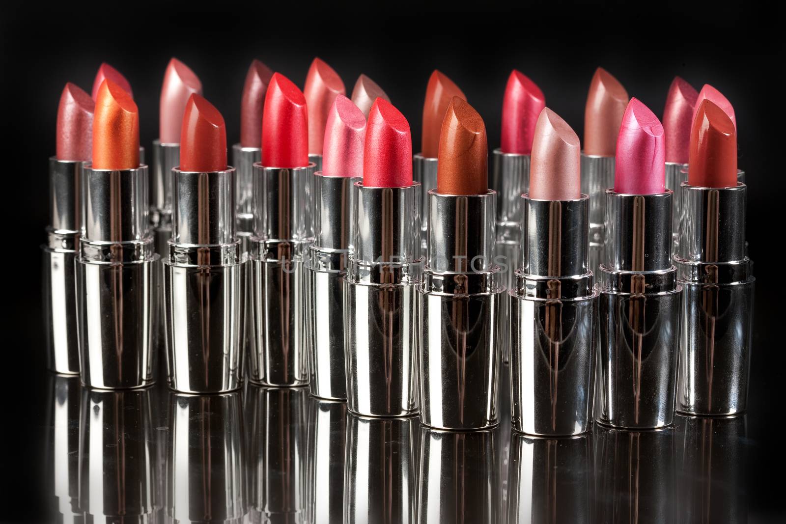 Tubes with different kinds of lipstick on studio background