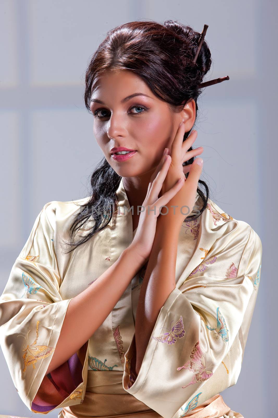 Young beautiful woman in japanese national clothing on an isolated studio background