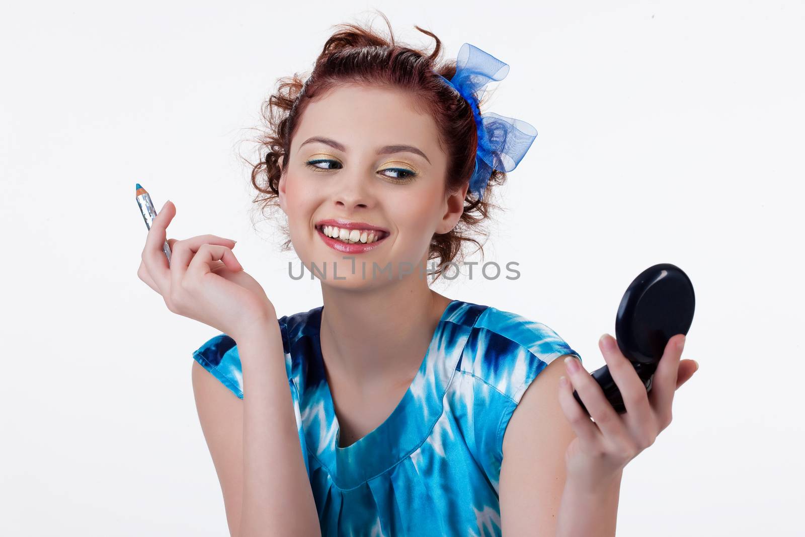 Young beautiful woman applying cosmetics onto her face