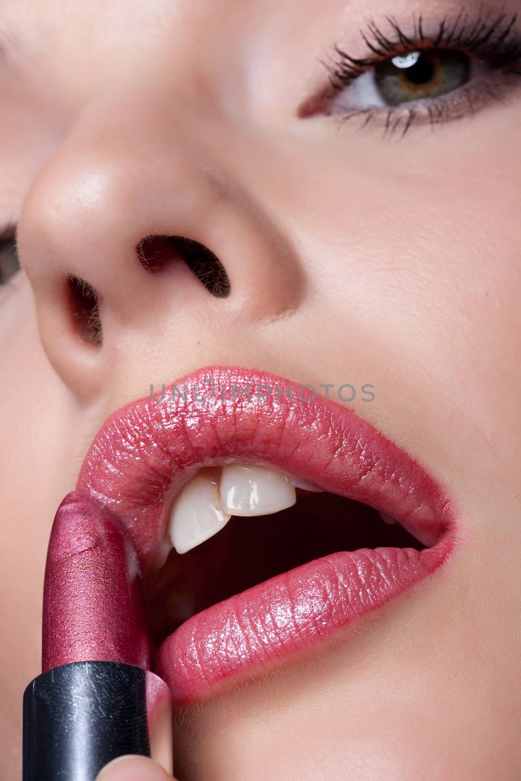 Young Woman Applying Cosmetics by Fotoskat