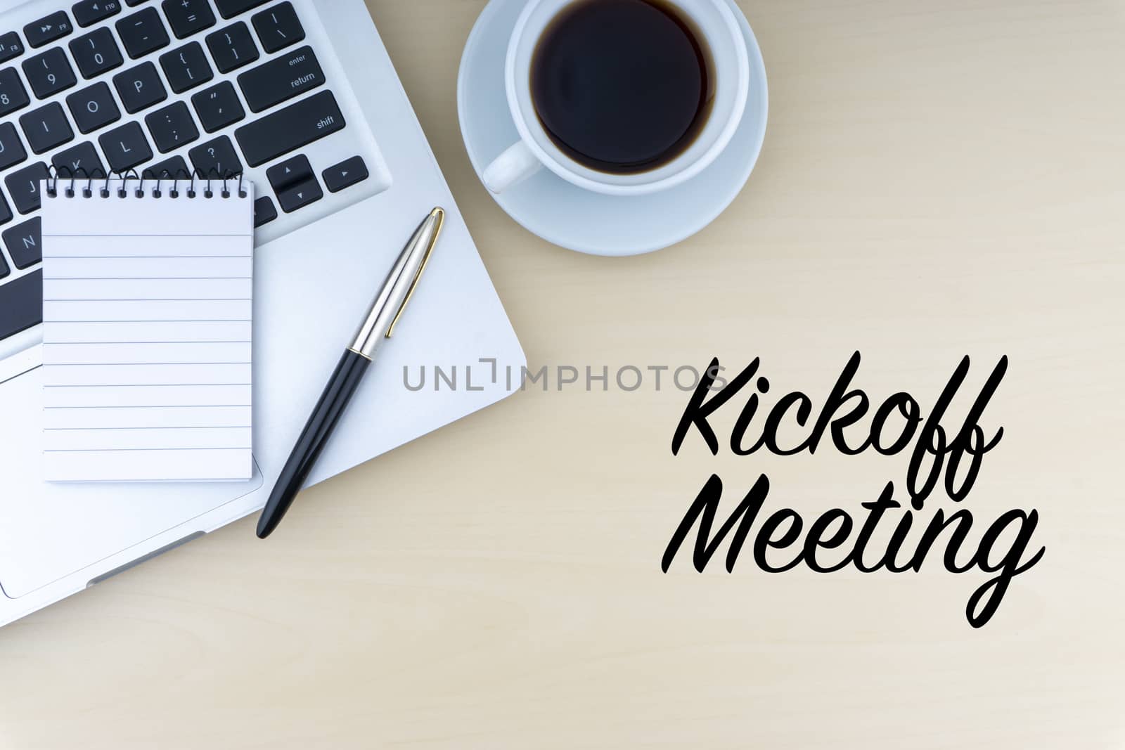 KICKOFF MEETING text with fountain pen, notepad, laptop and cup of coffee on wooden background by silverwings