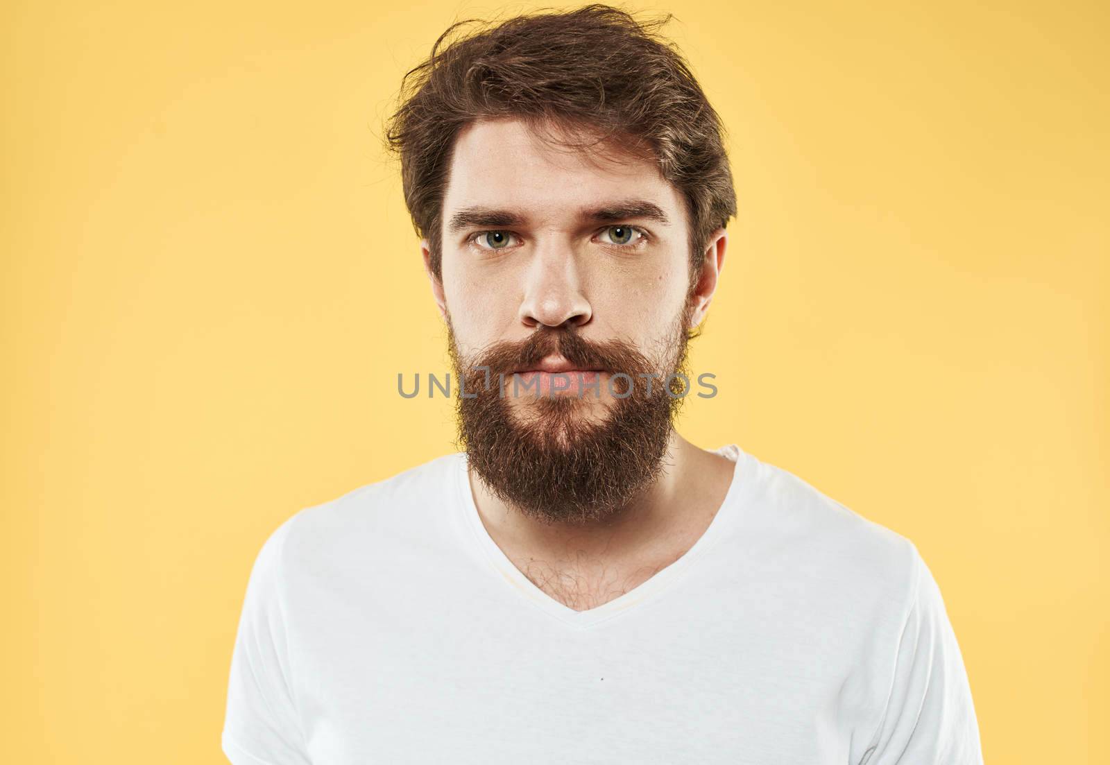 A man with a beard and mustache on a yellow background and a white T-shirt by SHOTPRIME