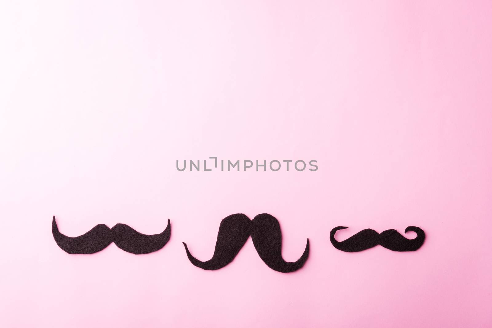 Black mustache paper, studio shot isolated on pink background, Prostate cancer awareness month, Fathers day, minimal November moustache concept