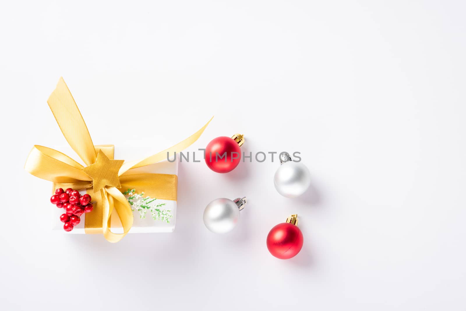 Christmas holiday composition top view flat lay of with a gift box and gold ribbon, fir branches, pine cones, and candy with copy space isolated on white background, New year day concept