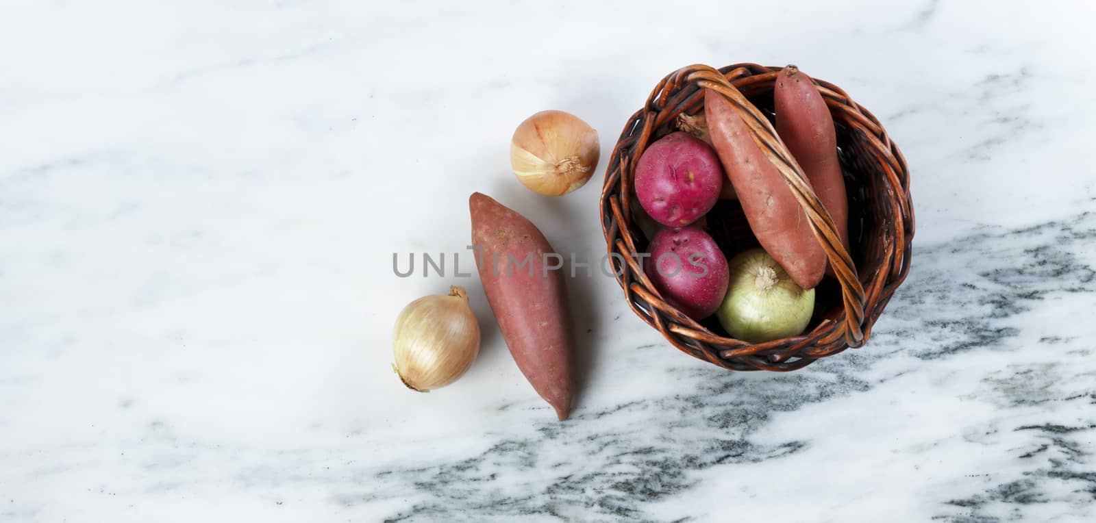 Basket of fresh raw organic vegetables on marble stone table  by tab1962