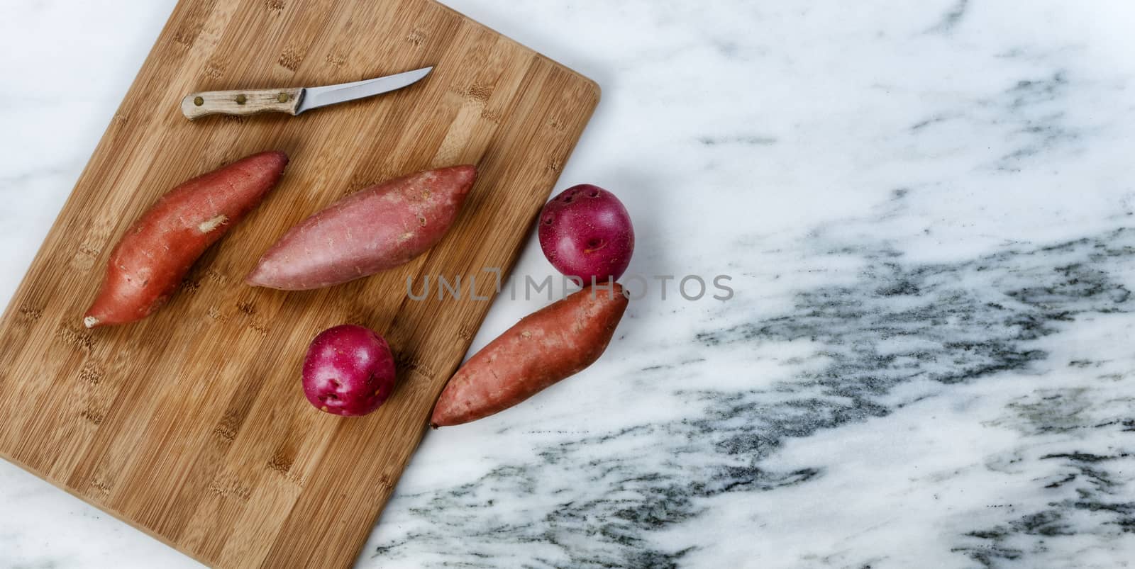 Fresh raw organic vegetables on marble stone table plus cutting  by tab1962