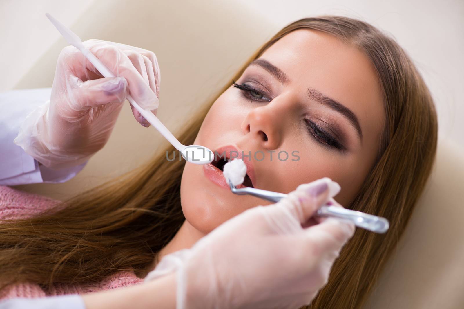 Woman patient visiting dentist for regular check-up by Elnur