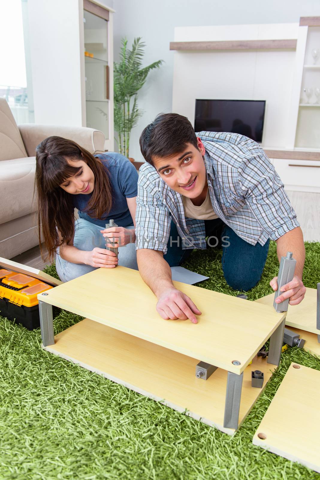 Young family assembling furniture at new house