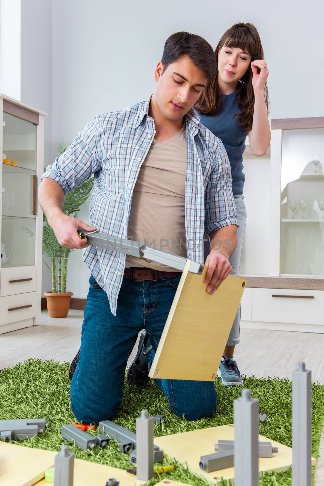 Young family assembling furniture at new house