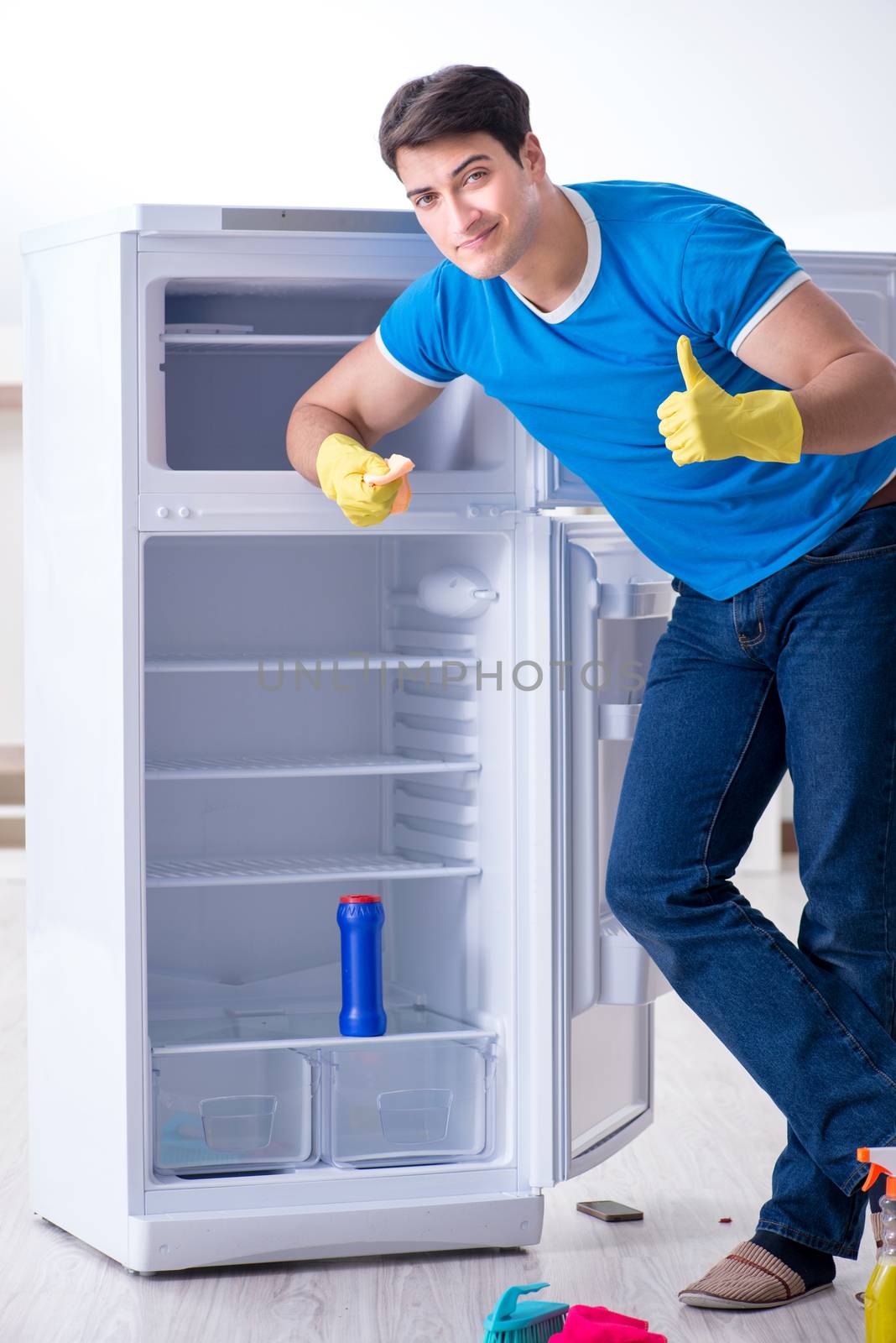 Man cleaning fridge in hygiene concept by Elnur