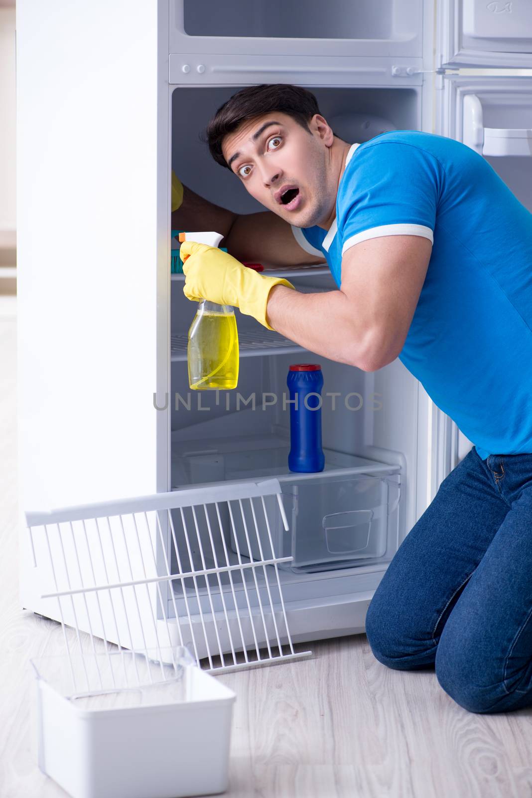 Man cleaning fridge in hygiene concept