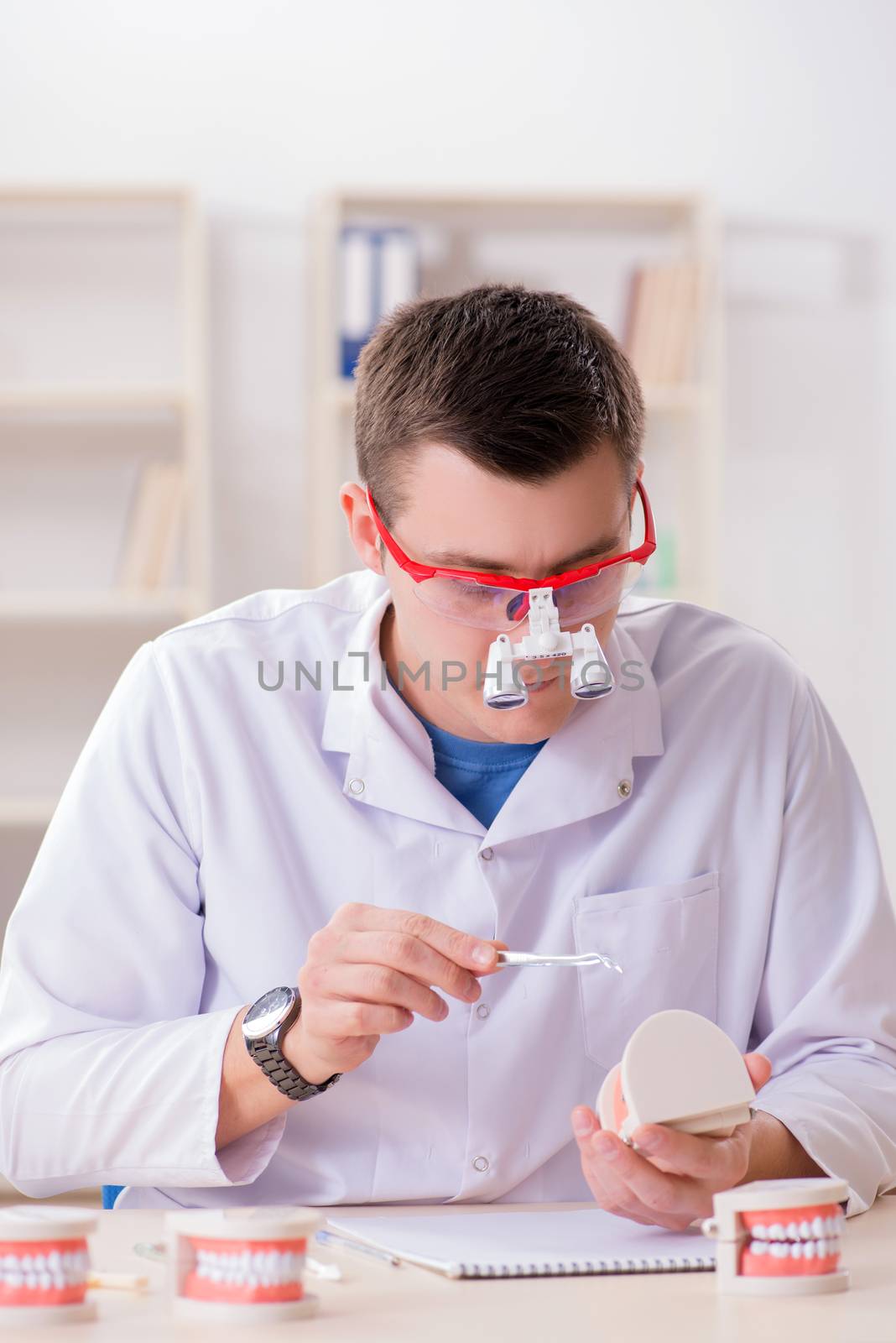 Dentist working teeth implant in medical lab