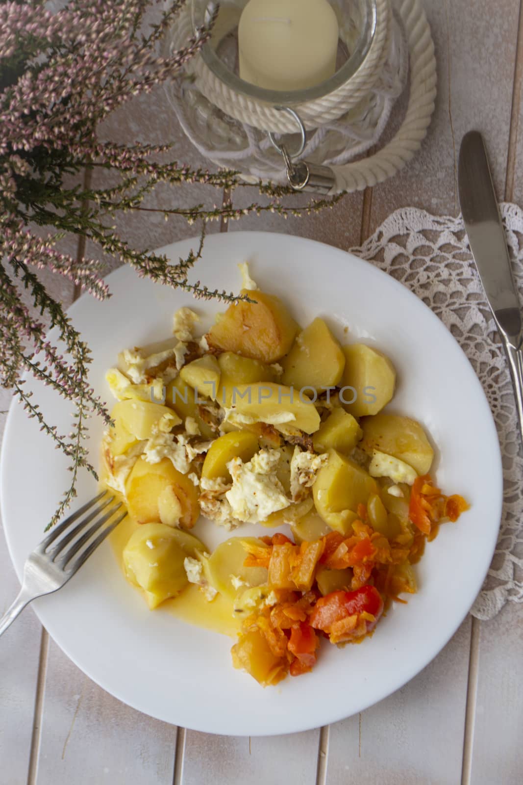 Boiled potatoes with vegetables on white plate. Flat view