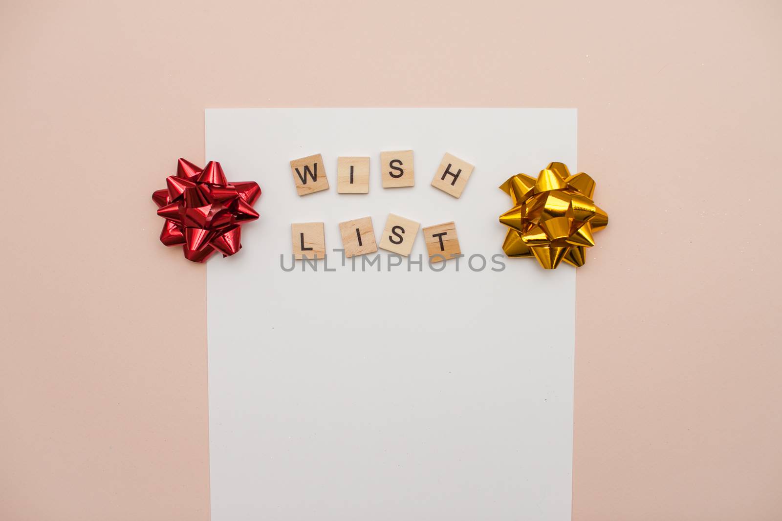 Inscription from wooden blocks wish list on a white blank sheet of paper. New Year's wish list. Letter to Santa Claus