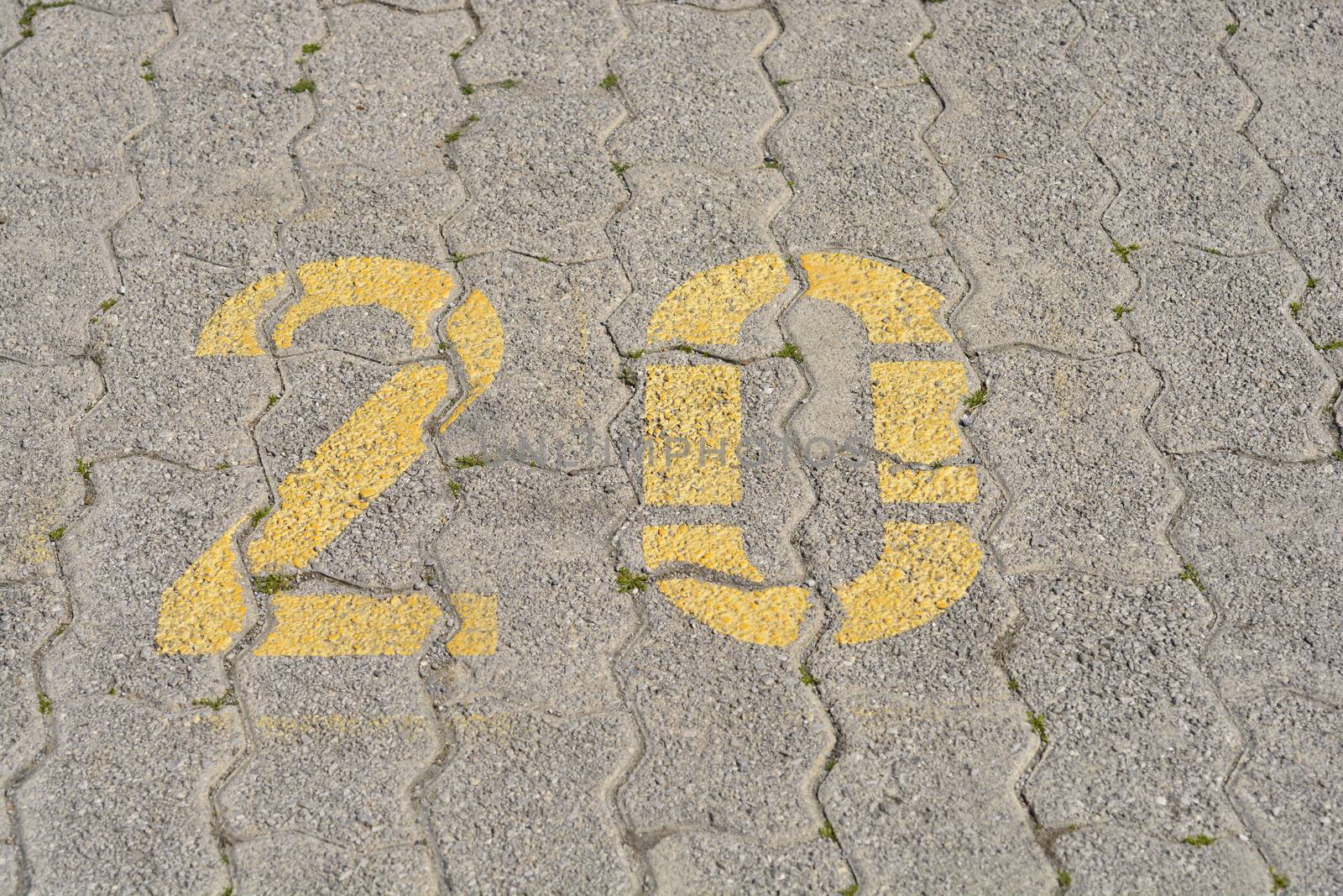 Close up of a parking spot with yellow number twenty