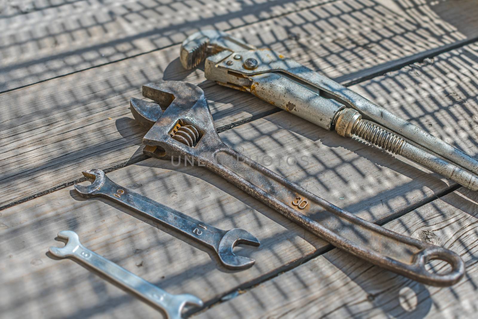 Set of wrenches and adjustable wrenches on a wooden floor