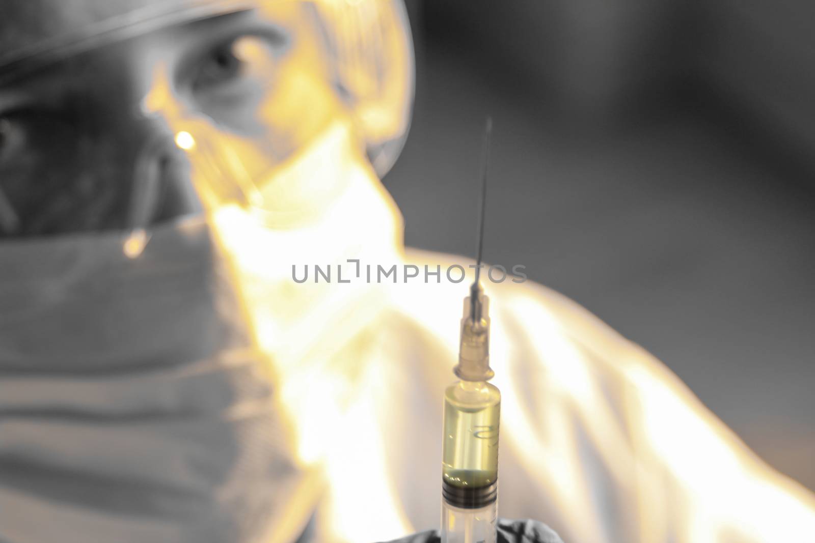 Madrid, Spain- November 25, 2020: Laboratory assistant wearing protective glasses and surgery gloves holding a syringe with Covid-19 virus vaccine