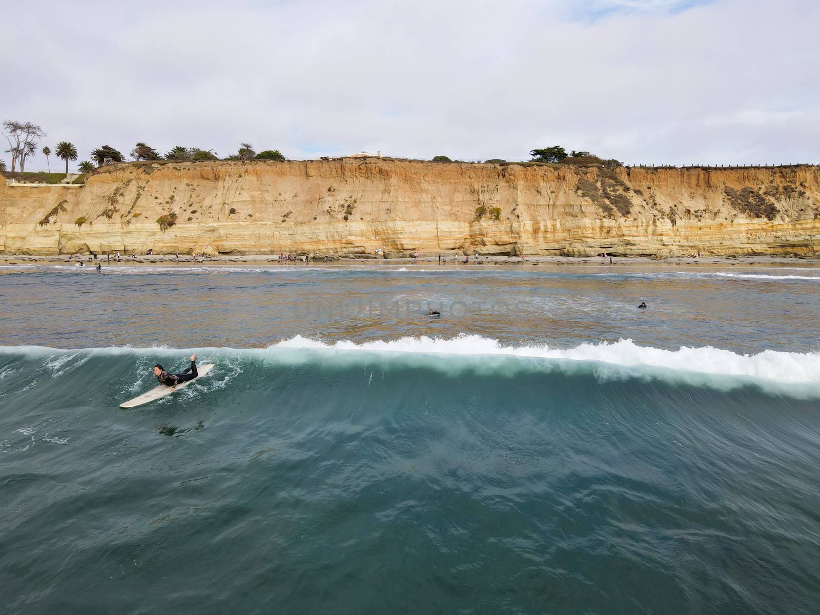 Surfers with wet suit paddling and enjoying the big waves. San Diego, California, USA. November 20th, 2020