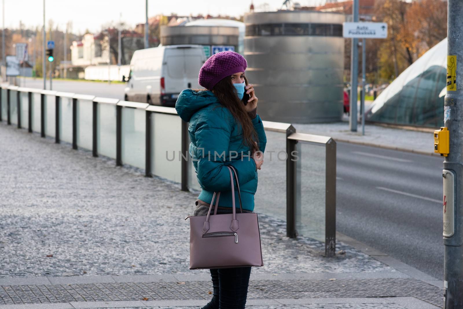 11-23-2020. Prague, Czech Republic. People walking and talking outside during coronavirus (COVID-19) at Hradcanska metro stop in Prague 6. Woman with mask waiting to cross..