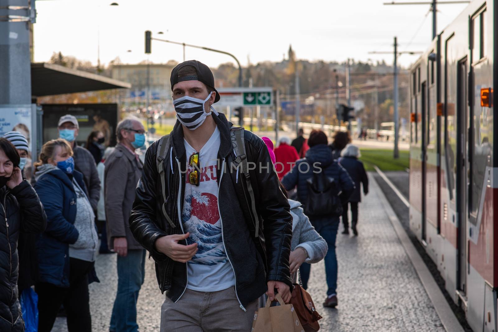 11-23-2020. Prague, Czech Republic. People walking and talking outside during coronavirus (COVID-19) at Hradcanska metro stop in Prague 6. Man getting out the tram.