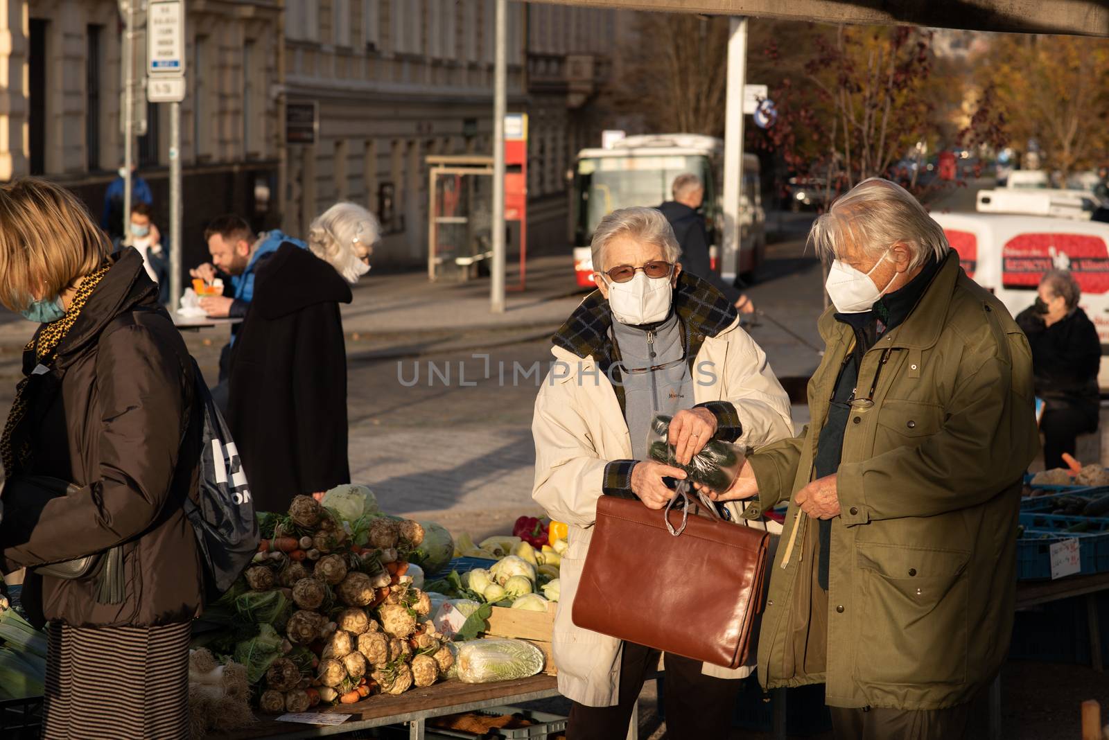 11-23-2020. Prague, Czech Republic. People walking and talking outside during coronavirus (COVID-19) at Hradcanska metro stop in Prague 6. Old people buying at the market.