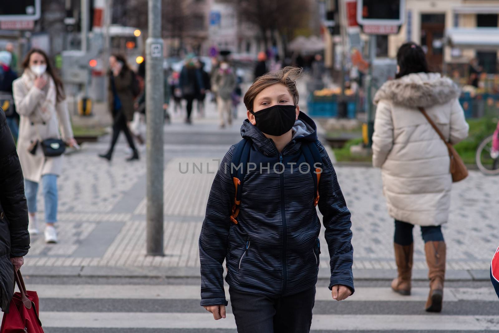 11-23-2020. Prague, Czech Republic. People walking and talking outside during coronavirus (COVID-19) at Hradcanska metro stop in Prague 6. Adolescent walking with mask.