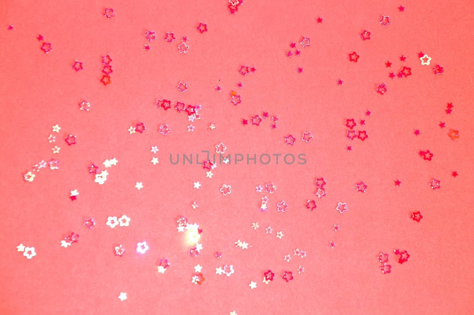 pink glittering stars on dark pink background close up