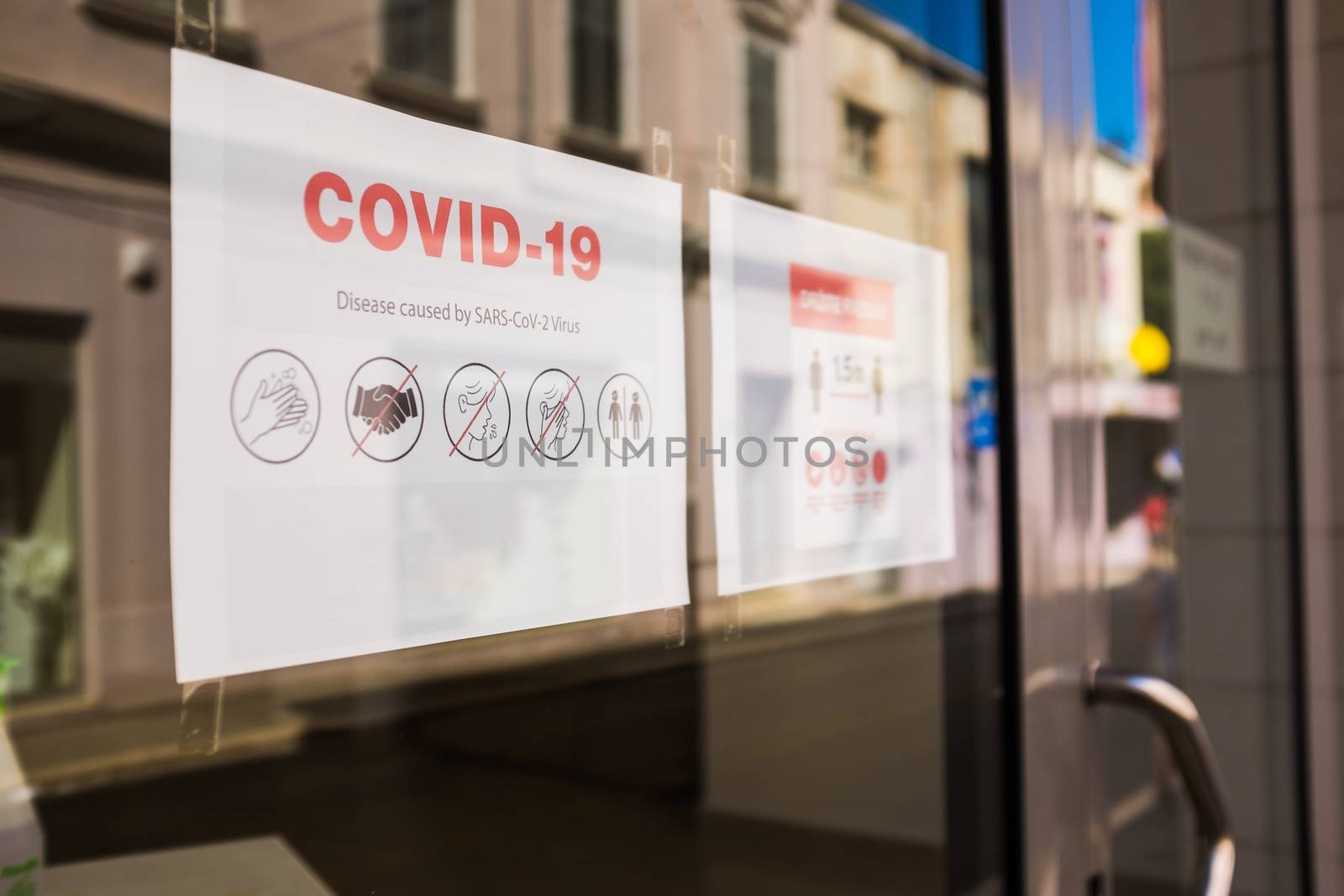 COVID-19 safety measures notice on store window by Plyushkin