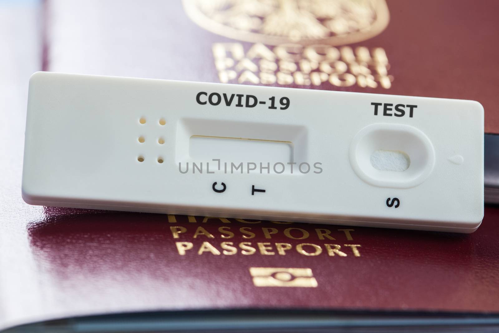 COVID-19 virus disease rapid testing kit on red passport by Plyushkin