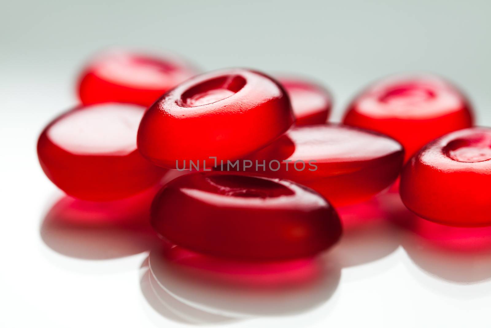 Pile of red pills isolated on white surface with reflection,medication concept,Coronavirus COVID-19 virus disease pandemic,research for cure and medication,therapy and remedy,prevention and protection