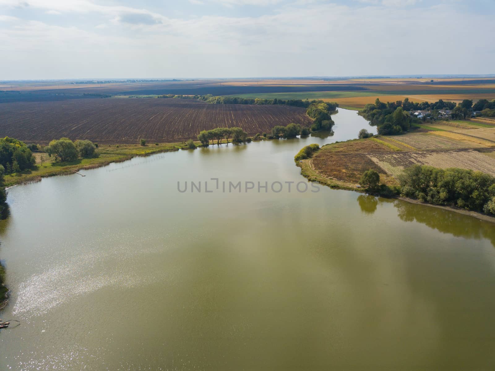 Aerial Drone View Above Large Lake near Wheat Agricultural Fields.