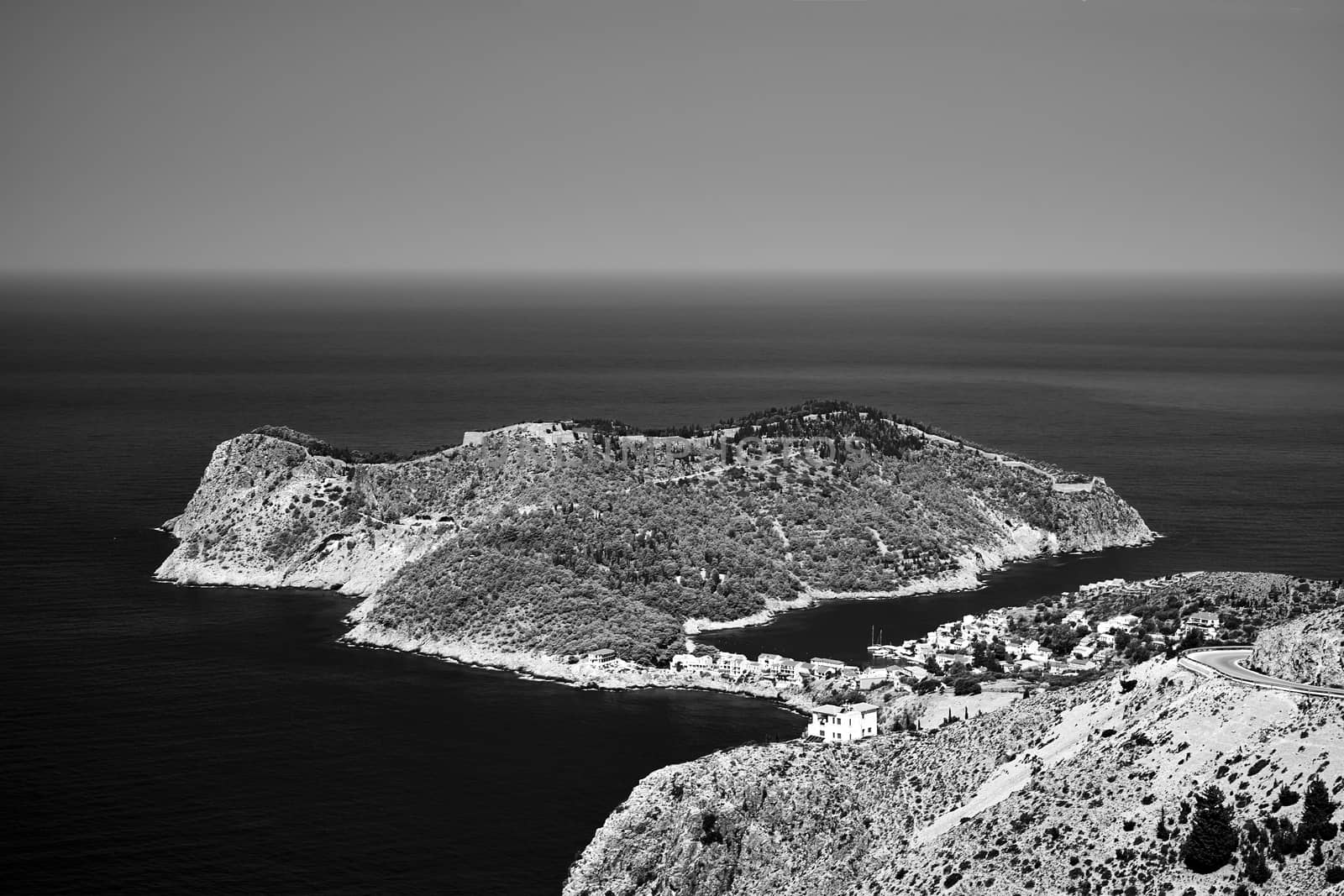 Peninsula with the city of Assos and the ruins of the Venetian fortress on the island of Kefalonia in Greece, monochrome