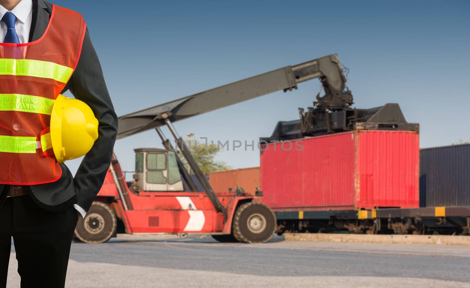 Businessman stand on front forklift loading Containers box by Sorapop