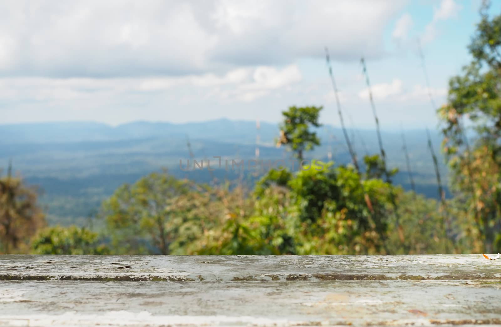 The iron table is empty on the background of forest, mountain and sky.