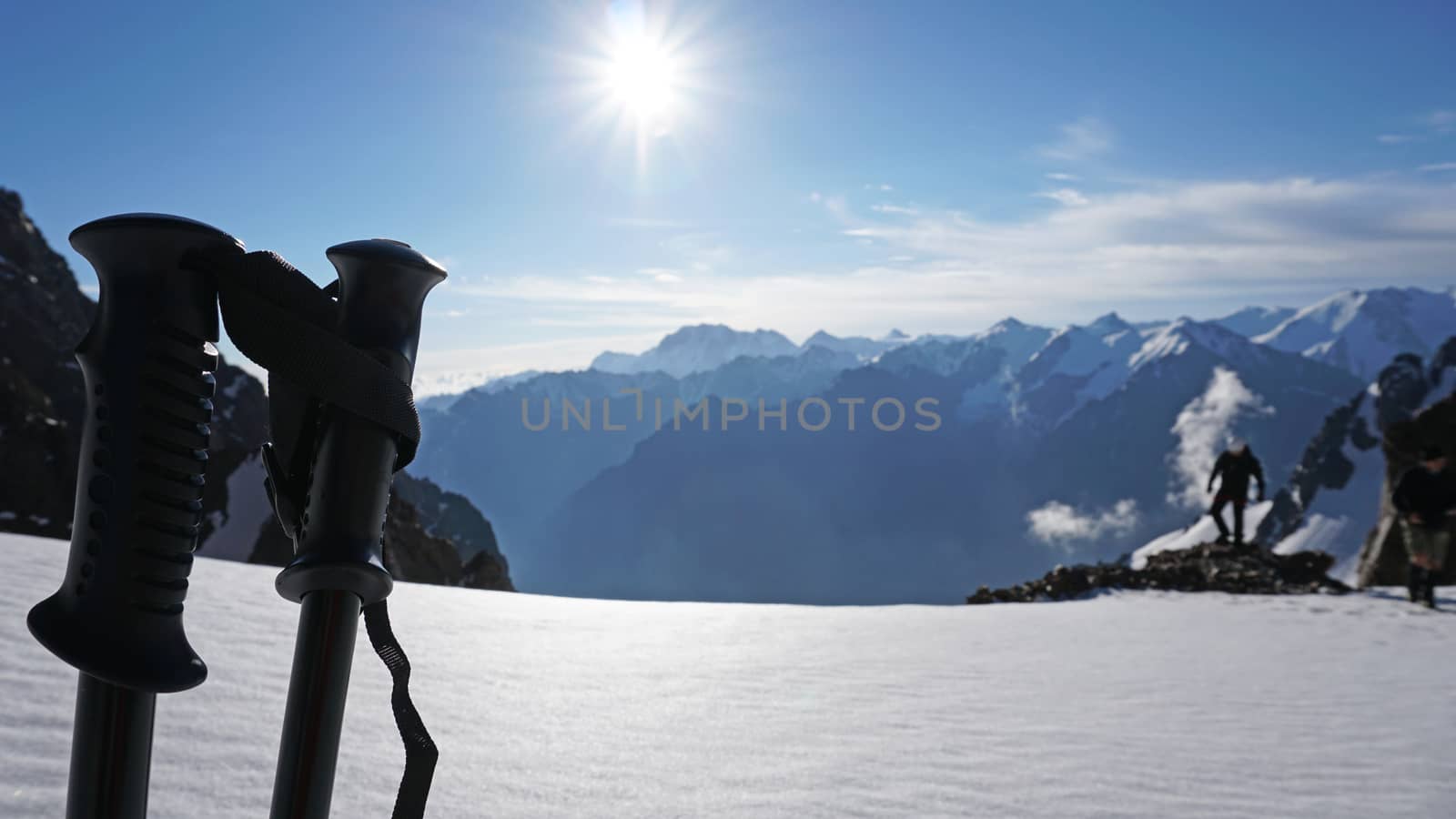 Trekking sticks on the background of snow peaks. by Passcal