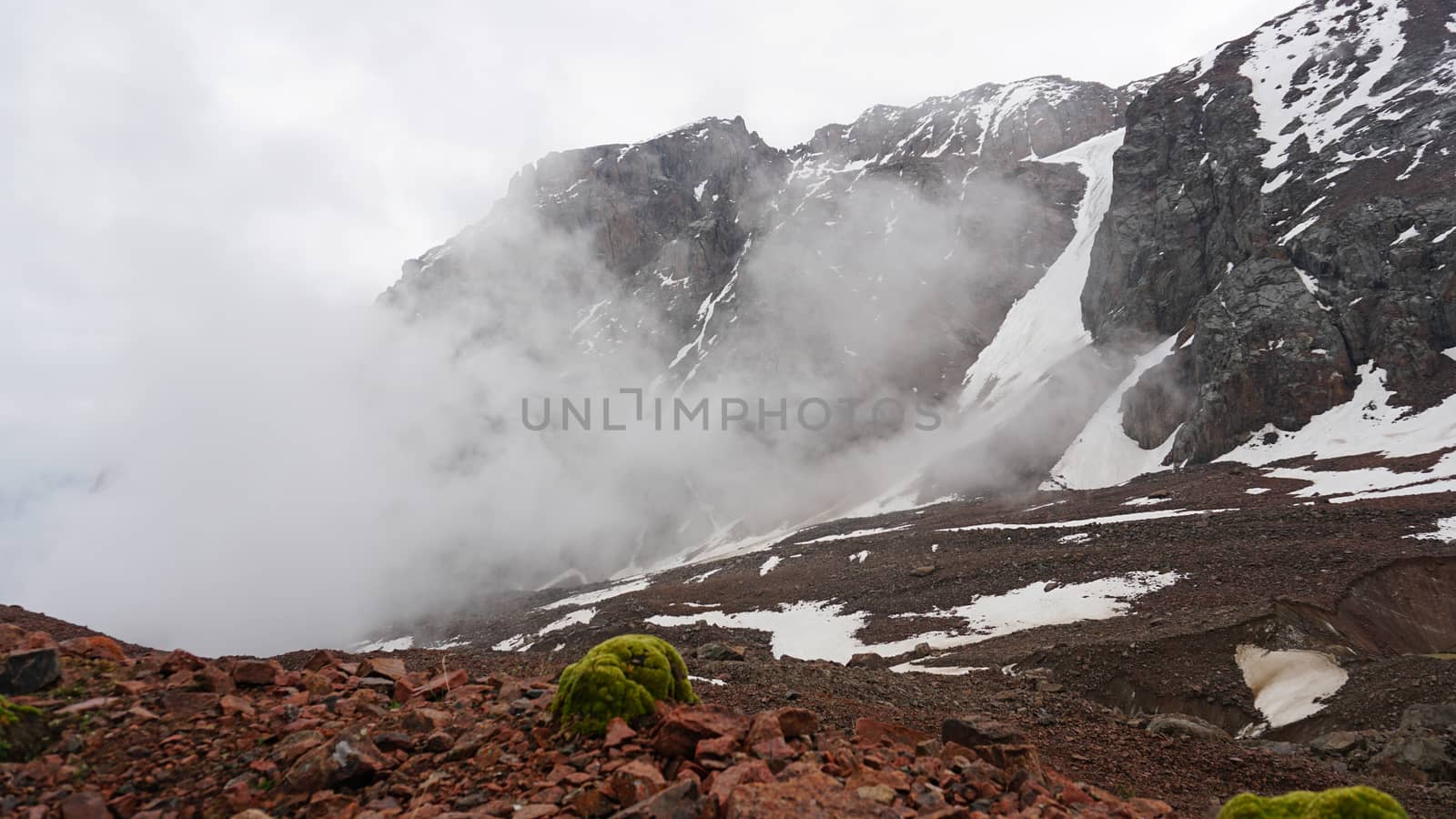 White clouds and snowy peaks. A lot of big stones by Passcal